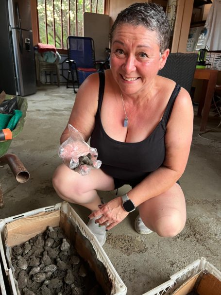 Sue Davies holding a baby turtle at Tambor Bay Turtle Project